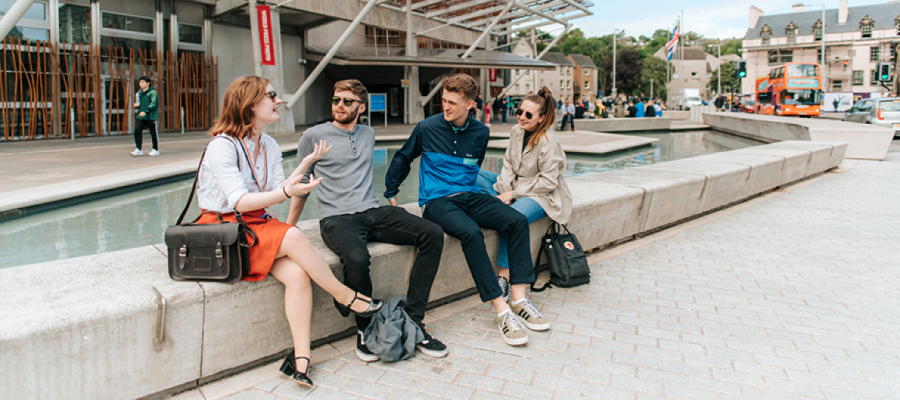 Group of Students sat outside building