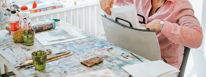 Woman putting art docs into a portfolio 