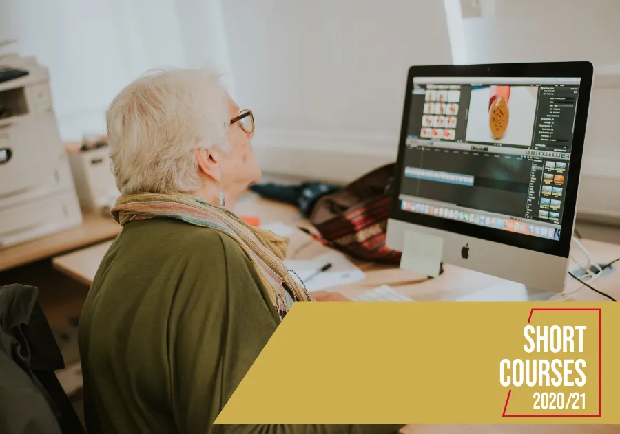 Image of woman sitting at a desk and looking at a computer screen