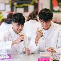 Two students at a table in a science class with test tubes