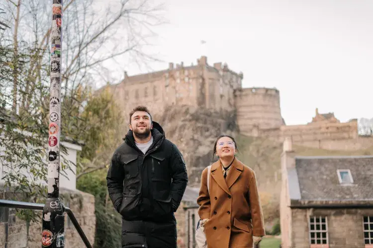Students walking in Edinburgh with views of Edinburgh Castle 