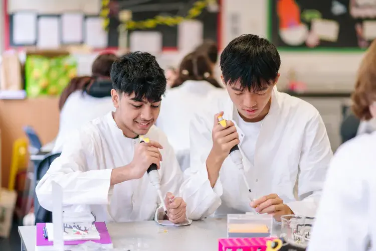 Two students at a table in a science class with test tubes