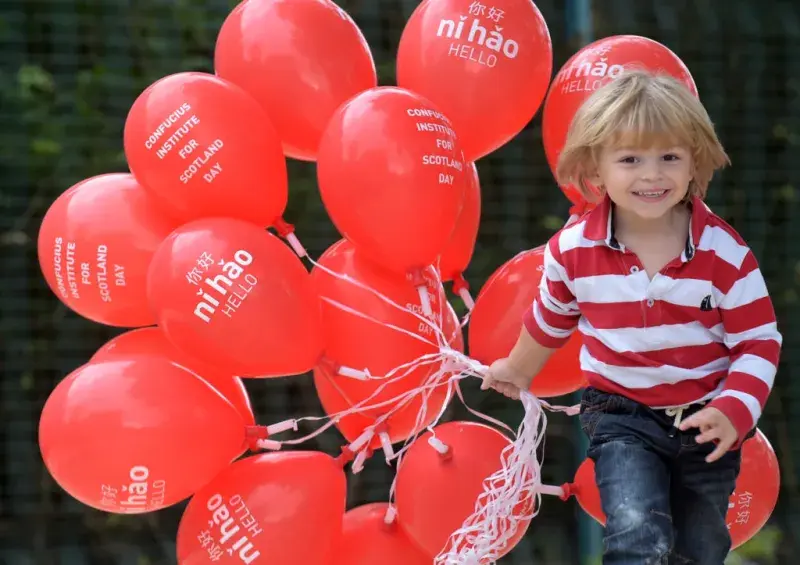 Image of child with red balloons with Chinese writing