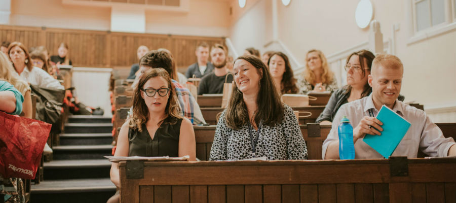 Students in a classroom in tiered seating.